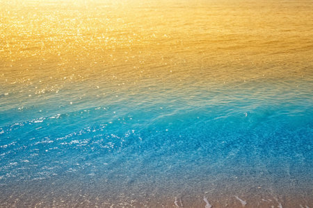 Golden sunset, turquoise waves, beach, calm ocean, summer vacation backgroundの素材
