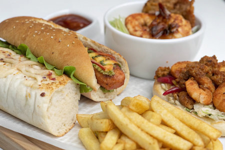 Delicious meal with hot dog, shrimp, fries, and sauce.の素材