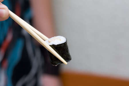 roll with egg taken with chopsticksの写真素材