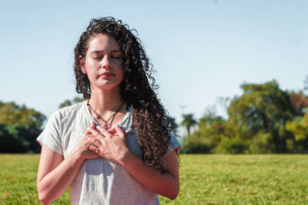 girl doing yoga pigeon pose in a park.の写真素材
