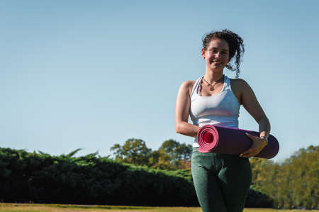 girl doing yoga pigeon pose in a park.
