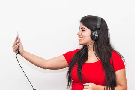 Hispanic Latina girl, white skin and black hair, dressed in red, is happy holding a cup of coffee...