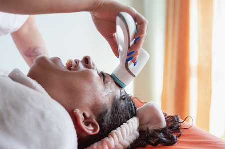 close up of the face of a Hispanic Latin brunette young girl lying face up on a therapy table,...