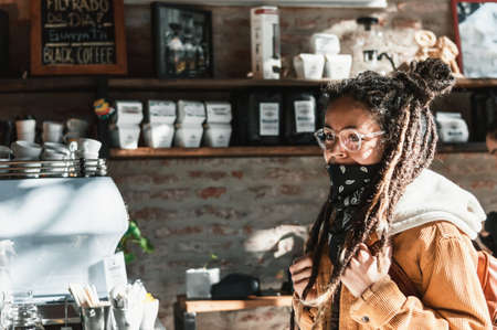 happy and pretty young white Hispanic Latin girl with big dreadlocks, glasses, backpack, black scarf...