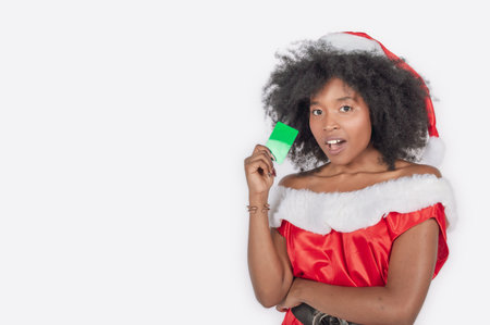 Standing young black woman dancing in a christmas dress over a white backgroundの写真素材