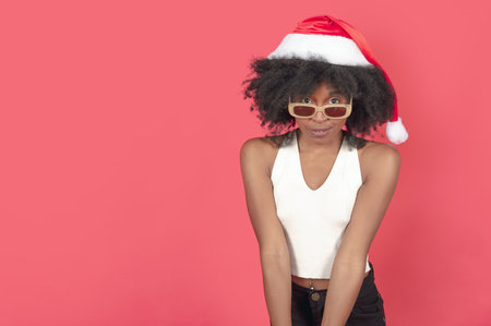 happy young woman giving a christmas present in a red costume, white copy spaceの写真素材
