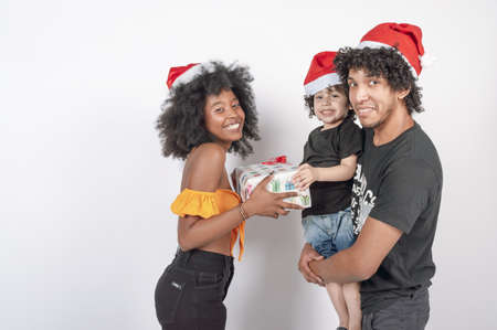 happy young woman giving a christmas present in a red costume, white copy spaceの写真素材