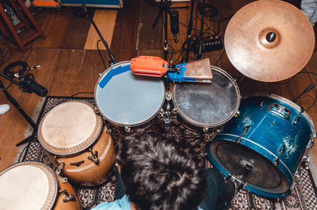 overhead view of a drummer playing latin music on an acoustic drum kit and congas, with microphones in a professional recording studio. music industry concept.の写真素材