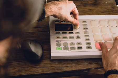 caucasian man making electronic music with a midi controller in his home studio, music industry and production conceptの写真素材