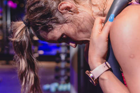 close-up profile young caucasian woman leaning forward training on abdominal machine, generating muscle contraction and burning fat.の写真素材