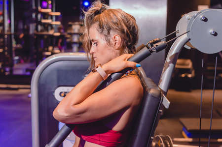 profile portrait caucasian young woman sitting on abdominal machine with eyes closed mentally...