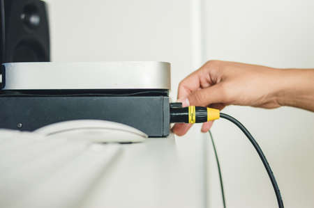 male hands in home studio moving the controls of an audio interface to record sounds with the microphone. music industry concept. copy spaceの写真素材