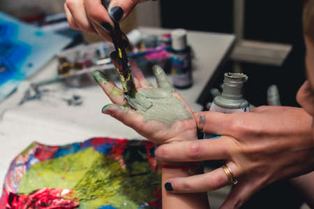 Caucasian boy in preschool gets his hand painted, children's creativity and crafts.の写真素材