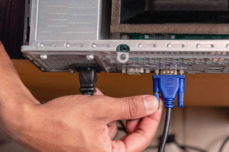 top view brunette male hand installing vga cable in computer, technology and technical service...