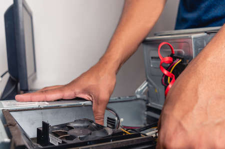 Unrecognizable brunette technician man installing ram memory in computer circuit, desktop computer...