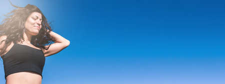 closeup latin caucasian sporty woman outdoors training, jogging with her eyes closed with the sky behind her with copy space. bannerの写真素材