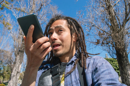 young latin venezuelan rasta man with casual clothes, he is outdoors standing in a public square...
