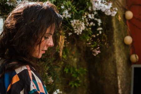 beautiful caucasian french adult woman looking down standing on the terrace of her houseの写真素材
