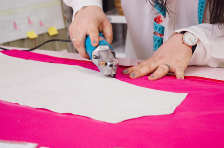 unrecognizable caucasian woman in her home workshop working cutting fabric with manual mechanical cutter, sewing concept, copy space.の写真素材