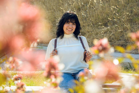 young latin woman smiling very happy to start studying at the university, she is sitting in the...