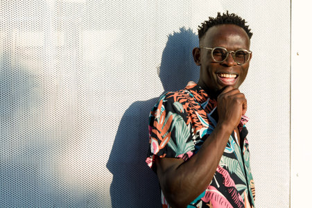 portrait of happy young man of african ethnicity, immigrant student in argentina, standing outdoors, posing looking at camera and smiling.の写真素材