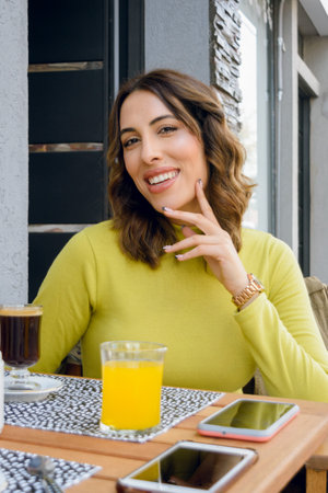 beautiful young hispanic latina woman of argentinian ethnicity with a green sweater, brown wavy...