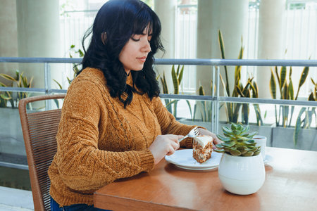 profile view of portrait of young latin woman with black hair and brown sweater, indoors very happy...