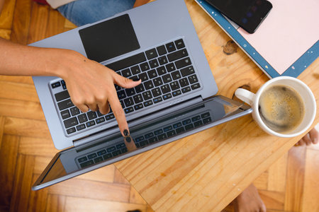 top view of unrecognizable brunette woman at home sitting touching laptop screen with finger on...