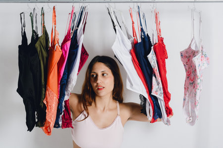 young latin argentinian woman in underwear posing on rack with underwear around her, closeup, studi photo with white background, lingerie conceptの写真素材
