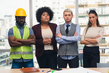 Corporate Portrait of Group of multi ethnic people from construction company in office, they are standing looking at camera posing seriously, there is man of African ethnicity with safety helmet.の写真素材
