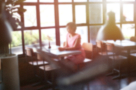 Women sitting in the coffee shop cafe for dating blur image use for background. Wife waiting her husband for having lunch in restaurant. Couple life concept background.の写真素材