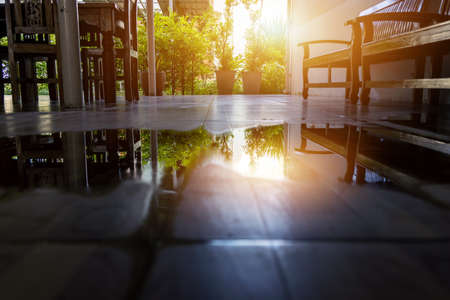 Spilled water on the house floor with the ray of sun light. Wet floor from rainy splash or pipelines...