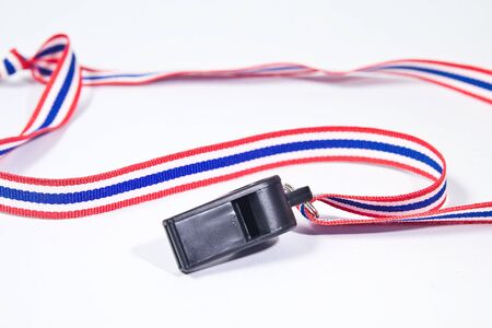 black whistle with Thailand national flag lanyard on white backgroundの写真素材
