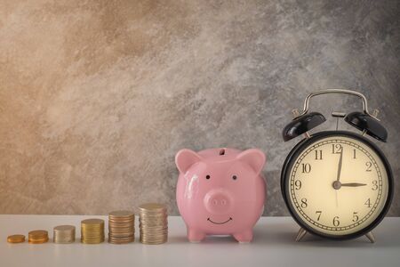 Close-up of clock and pink piggy bank smile with coins stack stair step up growing growth saving money. concept Business Finance, Time and Save money for future. with copy space.の写真素材