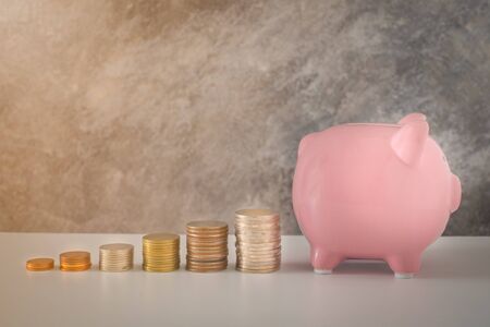 Close-up of pink piggy bank smile with coins stack stair step up growing growth saving money. concept Business Finance, Save money for future. with copy space.の写真素材
