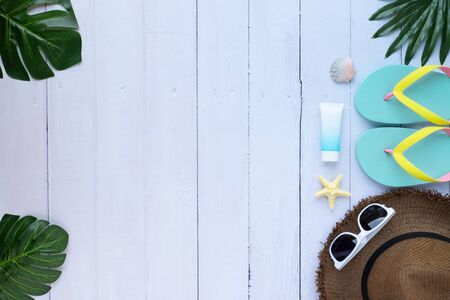 Summer holiday of traveler. Top view from above of beach accessories and a hat with sunglasses and sandals on white table background. Flat lay with copy space. Tropical fashion vacation concept.の写真素材