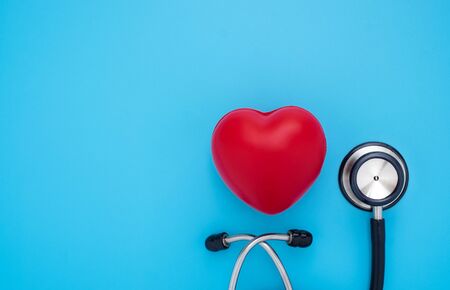 Close-up of Black stethoscope with red heart of doctor for checkup on blue