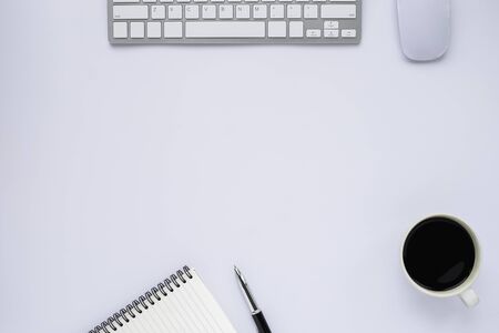 Top view above of White office desk table with keyboard, notebook and coffee cup, mouse with equipment other office supplies. Business and finance concept. Flat lay with blank copy space.の写真素材