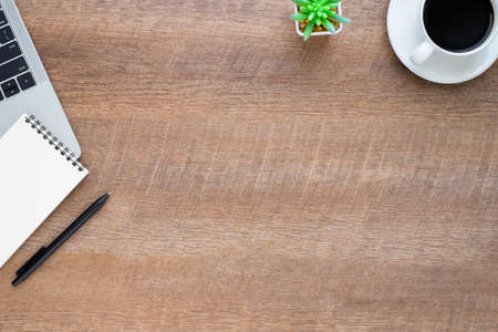 Top view above of Wood office desk table with laptop, notebook and coffee cup with equipment other office supplies. Business and finance concept. Workplace, Flat lay with blank copy space.の写真素材