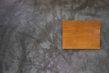 Brown wooden sign on a concrete gray grunge wall background. old abstract texture as a retro pattern...