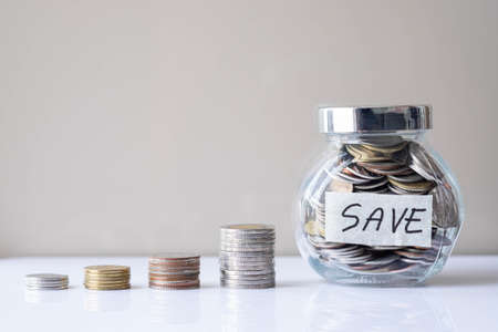 Business investment and finance accounting concept. Coins in glass bottle with money stack step up growing growth. Saving money with copy space.の写真素材