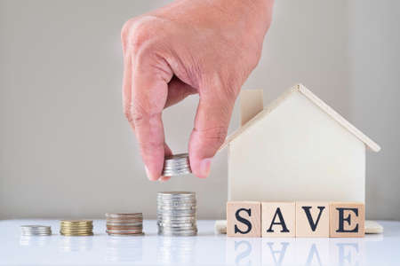 Real estate, Business investment and finance accounting concept. Hand putting coins into stack step...