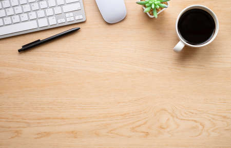 Top view above of Wooden office desk table with keyboard, notebook and coffee cup with equipment other office supplies. Business and finance concept. Workplace, Flat lay with blank copy space.の写真素材