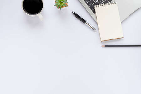 Top view above of White office desk table with keyboard, notebook and coffee cup with equipment office supplies. Business and finance concept. Workplace, Flat lay with blank copy space.の写真素材