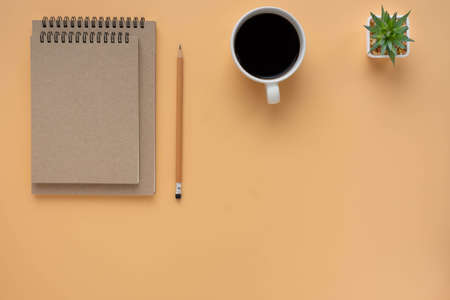 Top view above of Two brown spiral school notebook and pencil with coffee cup isolated on brown...