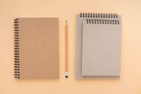 Top view above of Three school book brown closed spiral blank paper cover notebook with pencil isolated on blue background for design a mockup. Education and business concept. flat layの写真素材
