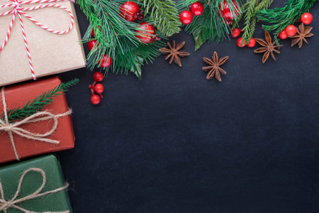 Top view above of Christmas holiday background. Composition with fir pine branches, Gift kraft box decorations on black background. Winter, Christmas, new year concept. Flat lay, copy space.の写真素材