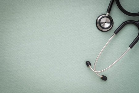 Close-up of Black stethoscope of doctor for checkup on light green background. Stethoscope equipment...
