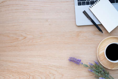 Top view above of Wooden office desk table with keyboard of laptop,  coffee cup and notebook with equipment office supplies. Business and finance concept. Workplace, Flat lay with blank copy space.の写真素材