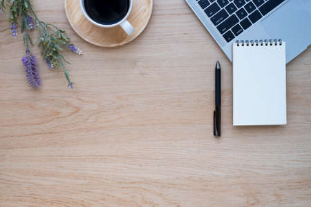Top view above of Wooden office desk table with keyboard of laptop,  coffee cup and notebook with equipment office supplies. Business and finance concept. Workplace, Flat lay with blank copy space.の写真素材